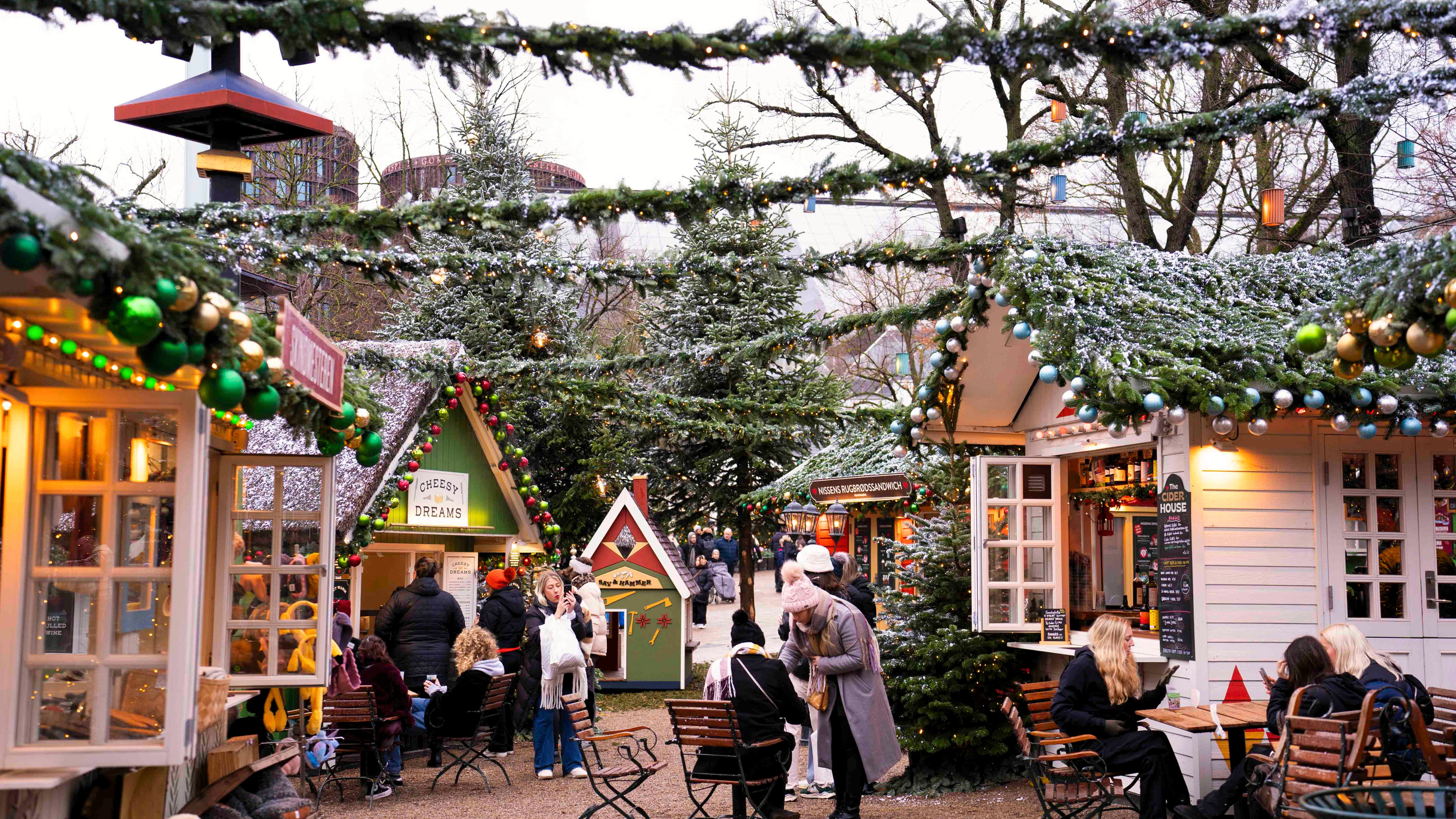 Juleboderne i Tivoli skaber en hyggelig og festlig atmosfære med smukke dekorationer og mennesker, der nyder julestemningen