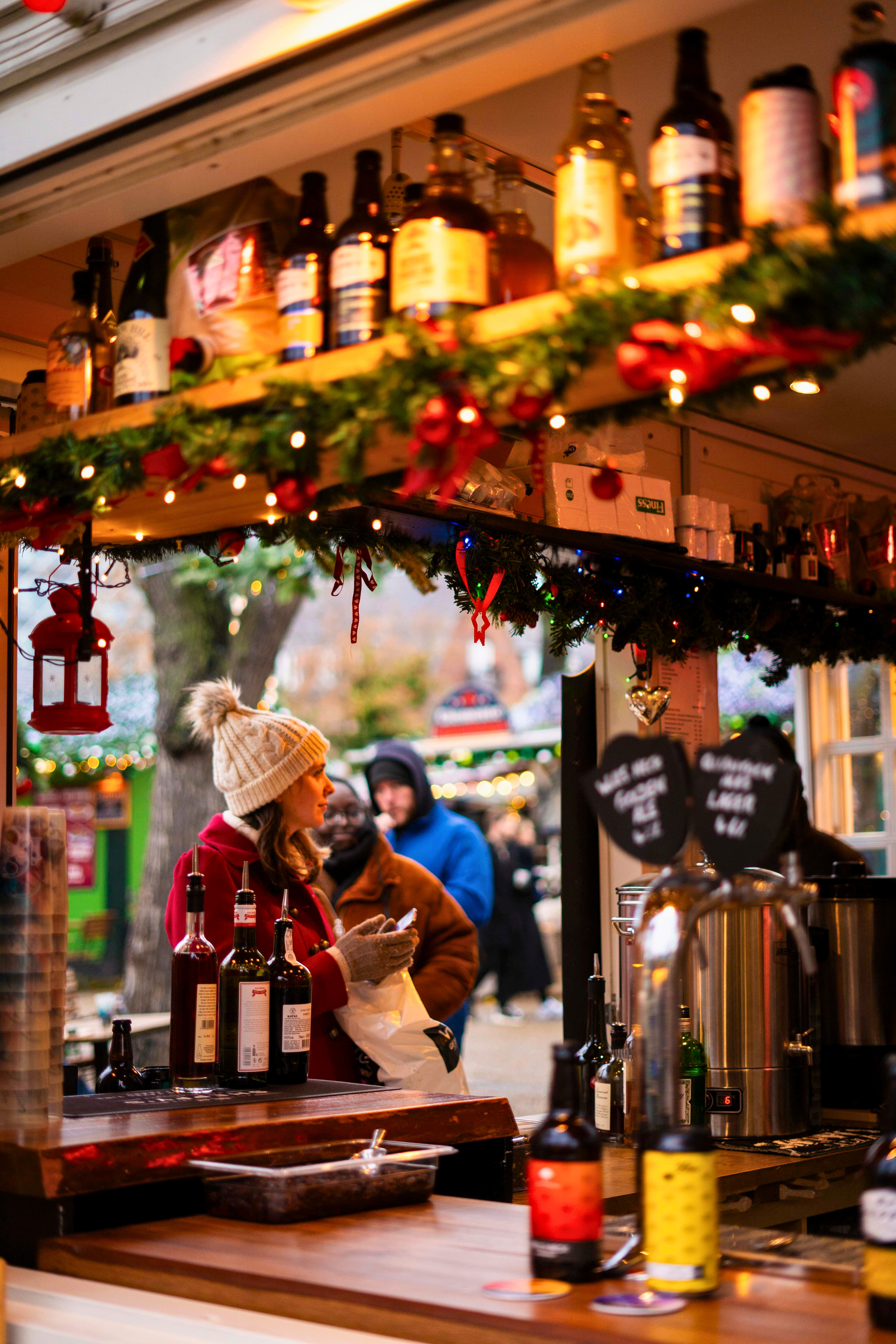 To kopper kaffe står på et cafébord. I baggrunden ses Haven i Tivoli pyntet med julelys, der skaber en hyggelig stemning. 