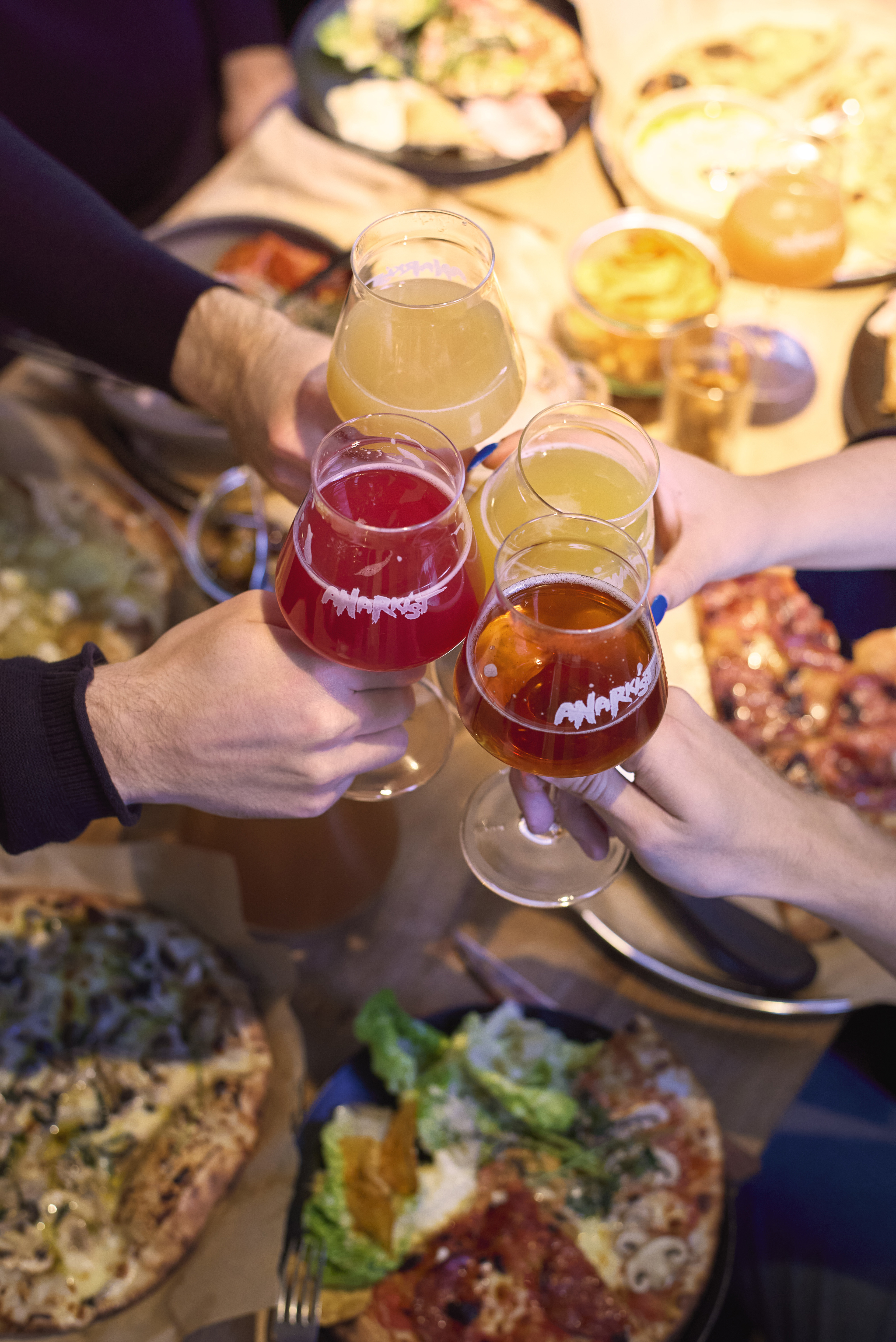 Hands raising a toast with different beers during a guided beer tour.